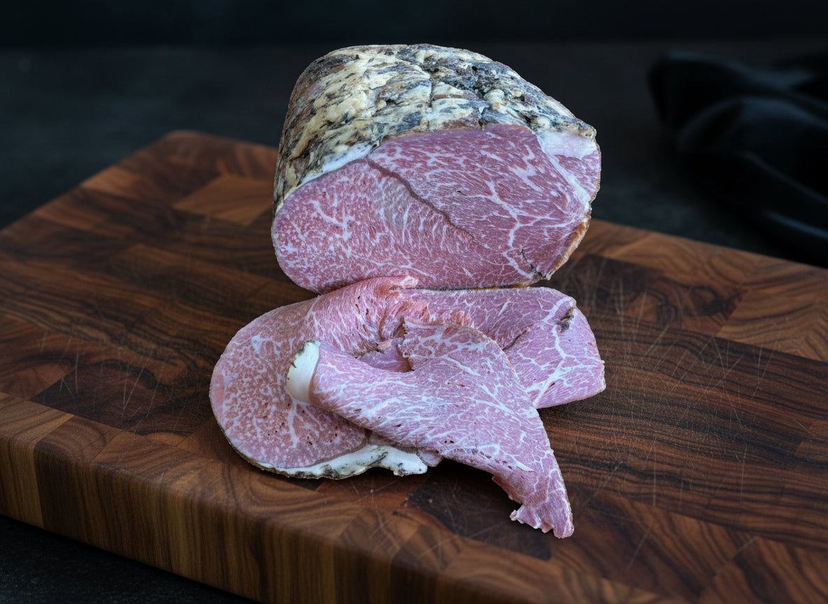 Sliced Wagyu ham on a wooden cutting board